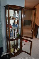Front view of two-door wood and glass display cabinet with doors open