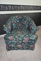 Front view of upholstered club chair showing floral fabric and cushioned seat.