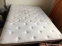 Full view of the mattress on bed frame with quilted diamond and circular pattern on mattress surface, no visible stains or tears.
