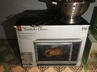Photo of boxed President's Choice convection rotisserie oven, 30L capacity, with metal colander and turkey lifting rack placed on top.