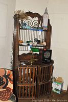Full view of the solid wood hutch bar with items placed on shelves for staging, showing its height, shape and detailing.