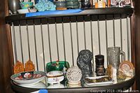 Wide view of the ornate shelf with all the assorted porcelain, glass, wood, and crystal ornaments arranged close together