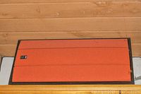 Front view of large Venturi speaker with orange fabric grille and dark wood cabinet.