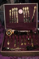 Full view of gold plated flatware set arranged inside tarnish-proof Naken silverware chest