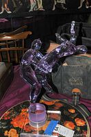 Front three-quarter view of the purple-tinted glass dancers on the Lucite base