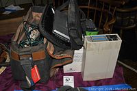NU View stereoscopic 3D camcorder adapter with original box, Toshiba portable DVD player in case, and carrying bag on a purple cloth