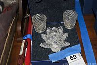 Photo showing the Swarovski Crystal Waterlily candleholder and two clear glass votive candleholders inside a foam-lined box.