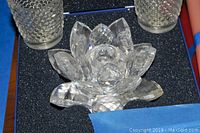 Top-down view of the Swarovski Waterlily candleholder and two bubble textured votive candleholders on black foam.