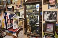 Full view of rectangular mirror showing carved wooden frame and mirror surface within a cluttered background.