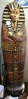 Front exterior of the closed sarcophagus bookcase showcasing painted and carved decoration