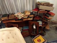 Photo of assorted vintage hardcover books stacked on furniture, showing different sizes and colors of bindings