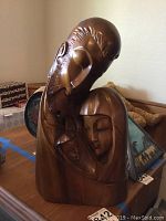 Front view of the carved teak Holy Family statue showing all three figures close together.