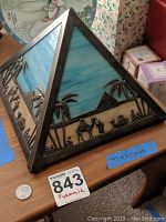 Front and side view of pyramid nightlight showing metal frame, colored glass panels, and Egyptian motifs in relief.