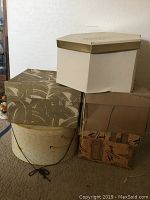 Five vintage hat boxes stacked, shows extent of lot and box conditions.