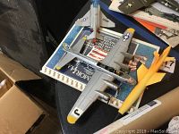 Photo showing the B-17G Flying Fortress model, wooden jet model, and memorial book on a table