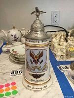 Front and side view of ceramic stein with detailed military insignia and inscriptions including Col. Robert W. Waltz and 86th Medics dates 1955 Germany 1956.