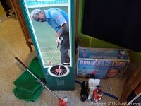 Photo showing Arnold Palmer Indoor Golf Game box with putter, ball, target and green stand, next to Bob Hope Action Golf Game box with remote control.