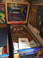 Full view of pinball machine showing cabinet, backglass, playfield and manuals