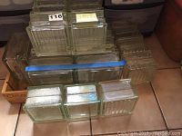 Seventeen glass block tiles arranged in rows with different patterns visible including ribbed vertical lines and smooth clear surface.