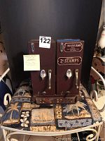 Full front view of the double postal stamp dispenser and postal scale showing two crank handles, two selector dials, and labels for 2-cent stamps.