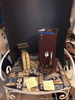 Photo showing the Pelouze postal scale and Schermack stamp dispenser placed side by side on a chair.