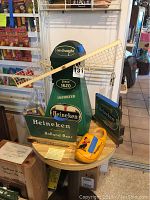 Heineken windmill display with signage and two light-up signs on a round table along with a yellow wooden shoe.