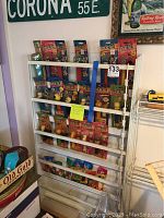 White metal wall rack with 25 Pez dispensers in original packaging and some loose at bottom