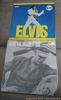 Front covers of two Elvis Presley vinyl LP albums, one blue double LP, one black and white titled Elvis: The Hillbilly Cat