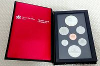 Opened Royal Canadian Mint case showing all seven proof coins in black display tray inside red presentation box.