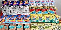 Shows an assortment of unopened hockey card packs from various brands and editions arranged on a surface.