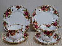 Two lunch plates and two teacups on saucers with Old Country Roses floral pattern and gold trim