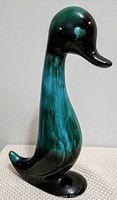 Side profile photo of the tall ceramic duck statue showing color gradient and shape.