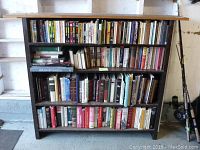 Front view of bookshelf filled with books on three shelves, showing the overall structure and book arrangement