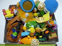 Top-down photo of assorted vintage Muppet toys piled together, showing various plastic figurine parts, bright colors, and a plush toy element.