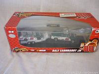 Front view of the boxed lot showing both the NASCAR stock car and truck inside the plastic display window.