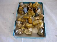 Box displaying approximately 18 assorted Wade ceramic figures including animals and characters.