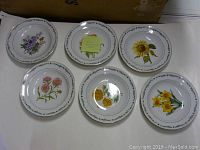 Photo showing all six vintage English soup bowls laid out on a surface with assorted floral designs visible on each bowl.