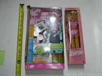 Two Barbie dolls in original boxes: NSYNC Fan Barbie on left, Funk 'N Glam Barbie on right, shown with a tape measure for scale.
