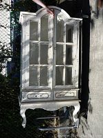 Full front view of the display case showing arched top, glass doors, drawers, and cabriole legs