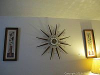 Overall display showing starburst clock flanked by two floral panel prints