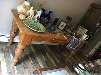Full angled view of the pine table with two drawers and various pottery and decor items on top, showing the turned legs and drawer fronts.