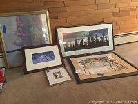 Photo showing all 5 framed artworks on floor, various sizes and styles including watercolor and lithograph.