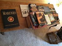 Wide view of all books laid out on a wooden table showing a mix of hard and softcover books, some with dust jackets.