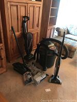 Photo showing all three vacuums including the Craftsman shop vac with missing leg, Oreck upright vacuum and Hoover Linx upright vacuum along with vacuum bags.