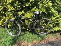 Side view photo showing the bike's frame, tires, and tool pouch attached to the seat.