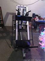 Front view of the Body Solid leg press and hack squat machine showing padded footrests and metal frame.