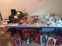 Whole table shown with various Christmas decorations on top and under it to illustrate lot content is only the folding table, not contents.
