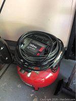 Top view showing the air compressor unit with black cover labeled '150 PSI' with coiled black hose and part of the power cord visible.