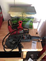 Black & Decker Sander Polisher Model 9531, Milwaukee Magnum Holeshooter drill, and hand-painted wooden box on a wooden table.