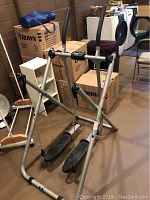 Full view of the Tony Little Gazelle Edge exercise machine showing metal frame with foot pedals and handles.